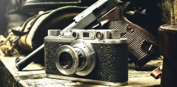 Old 1930 Pistol And Photo Camera Laying On a Table