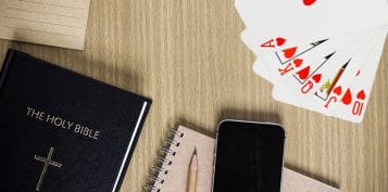 Notebook Bible and Playing Cards on a Table