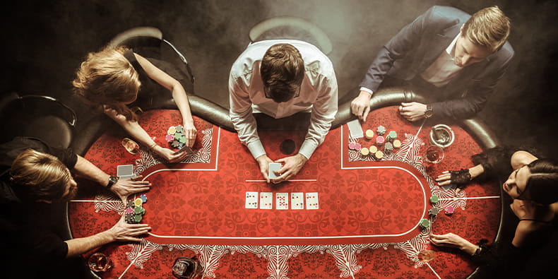 Table of Four Playing Poker with Croupier